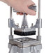 A hand holding a Nemco Easy Chopper pusher assembly.