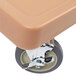 A tan plastic Cambro Camdolly with wheels and a handle.