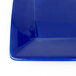 A close up of a Tuxton cobalt blue square china plate.