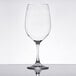 A clear plastic wine glass on a reflective surface.