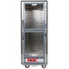 A gray Metro C5 hot holding cabinet with clear Dutch doors and shelves.