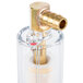 A close up of a gold and brass ARY Vacmaster oil and gas separator with a clear plastic cover.