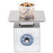 An Edlund Premier Series portion scale weighing nuts and seeds in a plastic container.