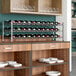 A Regency wire wine rack holding wine bottles on shelves.