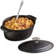 An American Metalcraft oval cast iron dutch oven filled with food on a hotel buffet table.