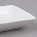 A white square porcelain sauce dish with 3 compartments.