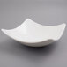 A white 10 Strawberry Street Whittier square coupe bowl with a curved edge.