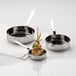 Three American Metalcraft mini stainless steel fry pans on a table with food in them.