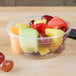 A Solo MicroGourmet plastic deli container filled with fruit on a table.