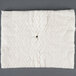 A white square cloth with a black spot on it with a hole in the center.