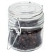 An American Metalcraft miniature glass hinged apothecary jar filled with black seeds.