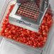 An Edlund Titan Max-Cut manual dicer on a counter with a tray of diced tomatoes.