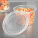 A plastic Solo deli container with a clear lid filled with beans and vegetables.