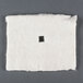 A square white piece of cotton with a square hole in the center.