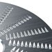A Waring shredder plate, a circular metal object with sharp spikes.