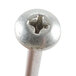 A close-up of a metal screw with a cross on top.