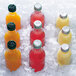 A Manitowoc undercounter ice machine bin with bottles of orange, yellow, and red drinks on ice.
