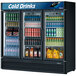 A Turbo Air Super Deluxe glass door refrigerator filled with soda cans.