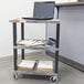 A gray Luxor Tuffy utility cart with a laptop on top.