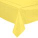 A yellow vinyl tablecloth with a crease on a table.