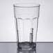 A clear plastic Cambro tumbler with a black rim filled with a clear liquid.