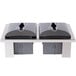 A close-up of two black and silver Steril-Sil napkin dispensing inserts on a table.