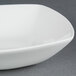 A CAC MAJ-B6 white bone china square bowl on a gray surface.