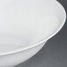 A white CAC bone china salad bowl with a white rim on a gray surface.