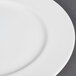 A close up of a CAC white bone china plate with a white rim.