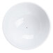 A bright white porcelain lid with a small black dot on a white background.