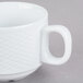 A close up of a CAC Boston super bright white porcelain cup with a handle.