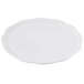 A white round display platter with a scalloped edge.
