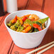 A white melamine bowl filled with stir fry vegetables and shrimp.