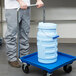A man pushing a Vollrath dolly with a large bucket.