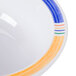 A white melamine bowl with a colorful diamond pattern on the inside.