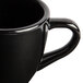 A close up of a black GET Elegance espresso cup with a handle.