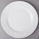 A white CAC porcelain plate with a circular edge on a gray surface.