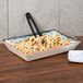 A GET Bella Fresco melamine tray with a bowl of pasta and a fork on a table.