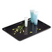A black rectangular melamine tray with small bottles of cosmetics and a bunch of green flowers.