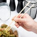 A person using Kari-Out Mikami bamboo chopsticks to eat from a bowl.