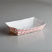 A white rectangular paper food tray with a red check design.