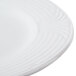 A close up of a CAC white porcelain plate with a wavy design.
