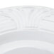 A close-up of a CAC white porcelain plate with an embossed design.