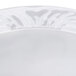A close-up of a CAC CRO-11 Corona white porcelain fruit bowl with an embossed design.