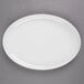 A white oval platter with a white rim on a gray surface.