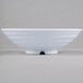 A white Milano melamine bowl with a white rim on a gray surface.