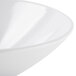 A close-up of a white GET San Michele slanted melamine bowl with a curved rim.