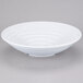 A white melamine bowl with a spiral design on a white surface.