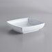 A white square GET Milano melamine bowl on a gray surface.