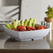 A white Milano melamine serving bowl with chicken wings and celery.